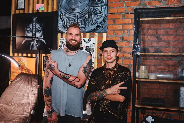 Мастера студии Only Tattoo в рабочем пространстве среди эскизов и работ на стенах
